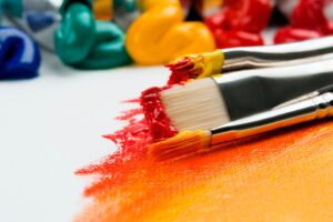Photo of paint brushes covered in paint.